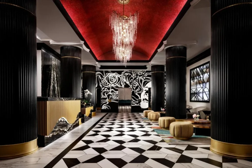 Lobby with fluted black columns, red vaulted ceiling and checkerboard marble floor at Hotel Beauden