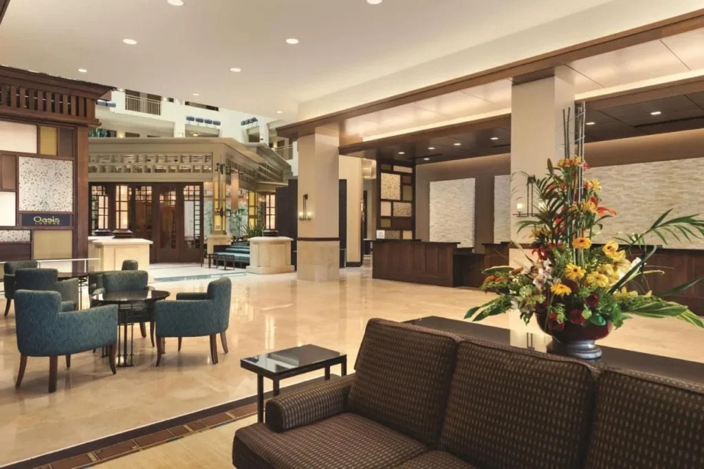 Lobby con recepci&oacute;n y tumbonas en Embassy Suites Lake Buena Vista South