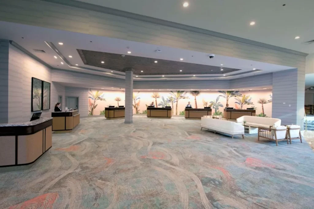 Lobby with front desks, tropical mural and white sofas at Caribe Royale Orlando