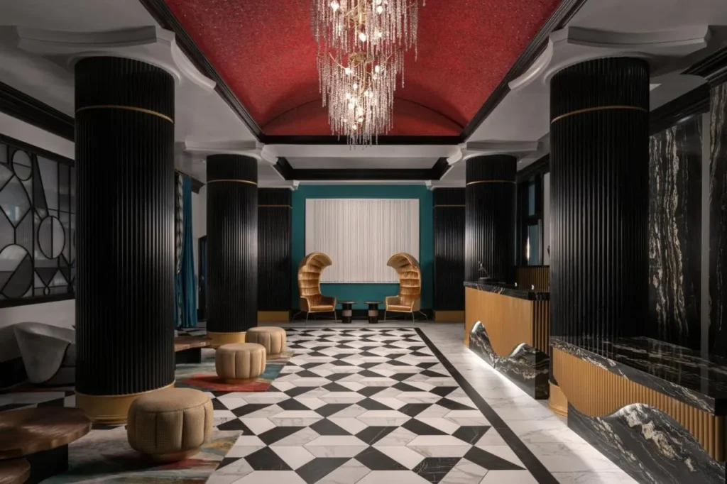 Lobby with red vaulted ceiling, crystal chandelier and checkerboard marble floor at Hotel Beauden