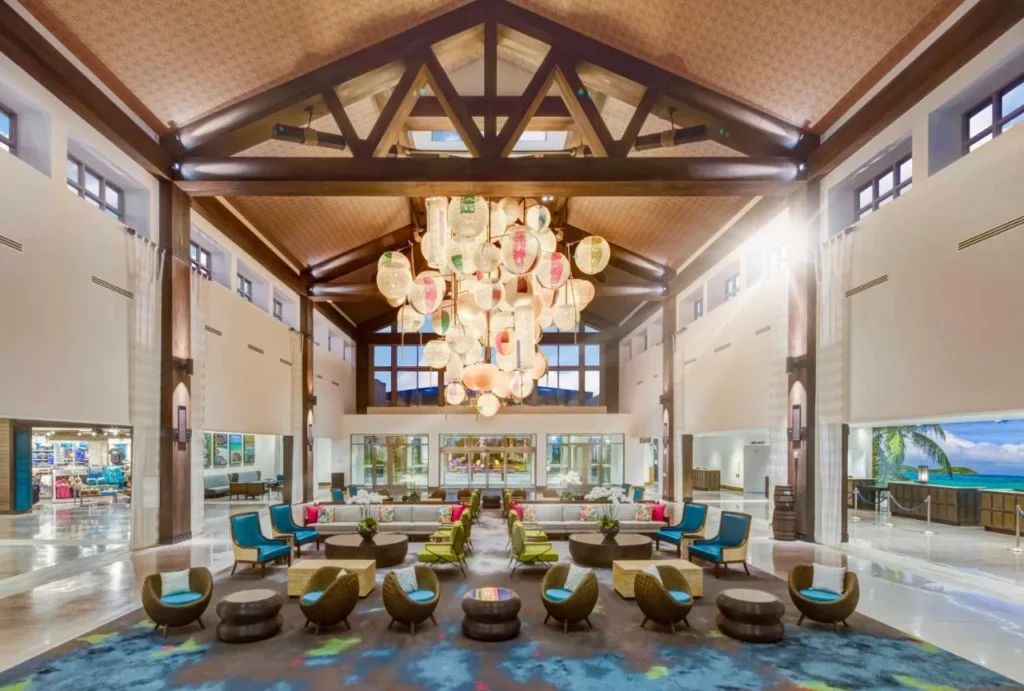 Lobby with timber beams, a lantern chandelier and wicker chairs at Loews Sapphire Falls Resort