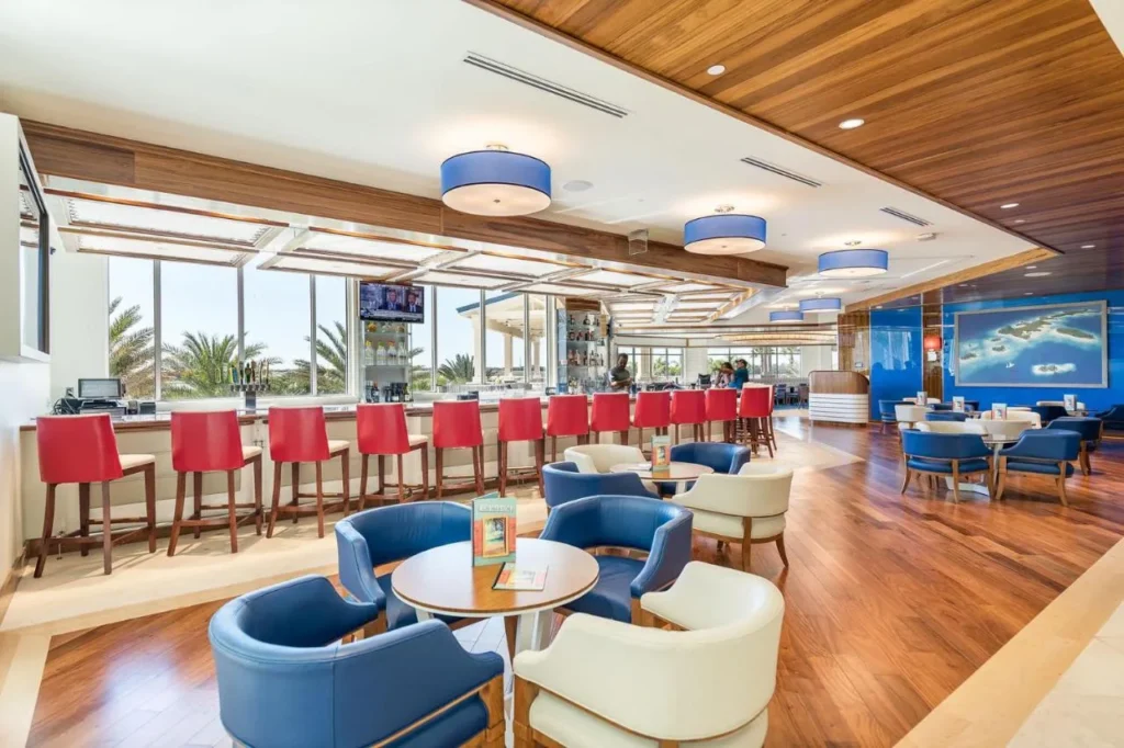 Lounge bar con taburetes rojos y sillones azules y blancos en Margaritaville Resort Orlando