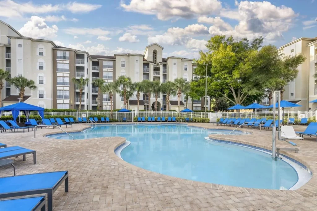 Piscina principal con tumbonas azules y edificios de suites en Hilton Vacation Club Grande Villas Orlando