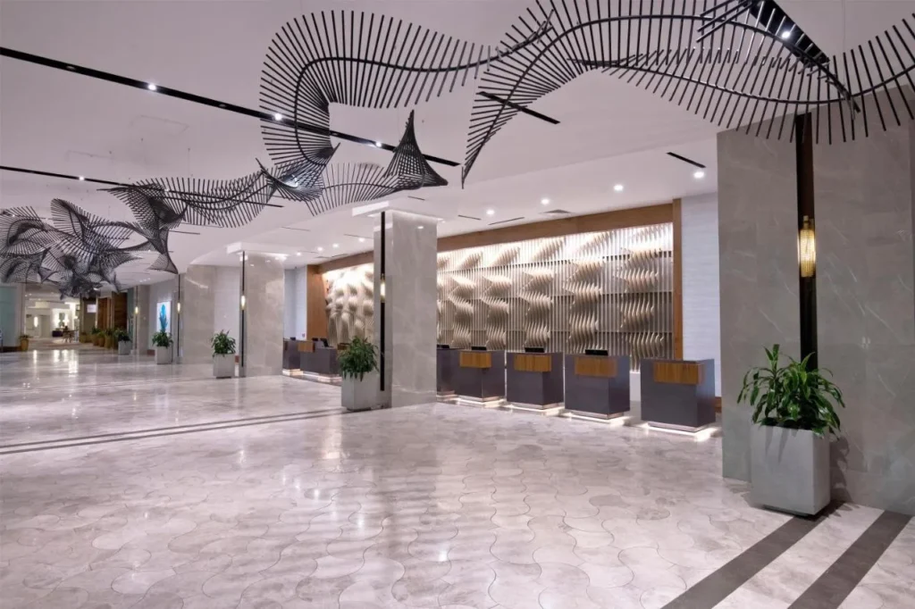 Marble lobby with check-in desks and a hanging wave sculpture at Hilton Orlando