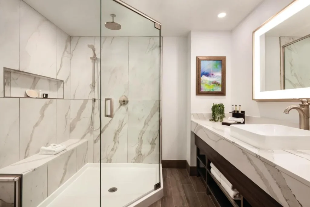 Marble walk-in shower and vessel-sink vanity in a suite bathroom at Buena Vista Suites