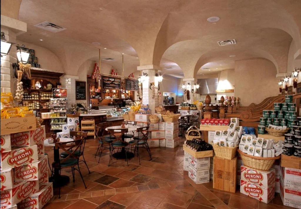 Deli estilo mercado con techos abovedados, mesas de café y comestibles italianos en Loews Portofino Bay Hotel