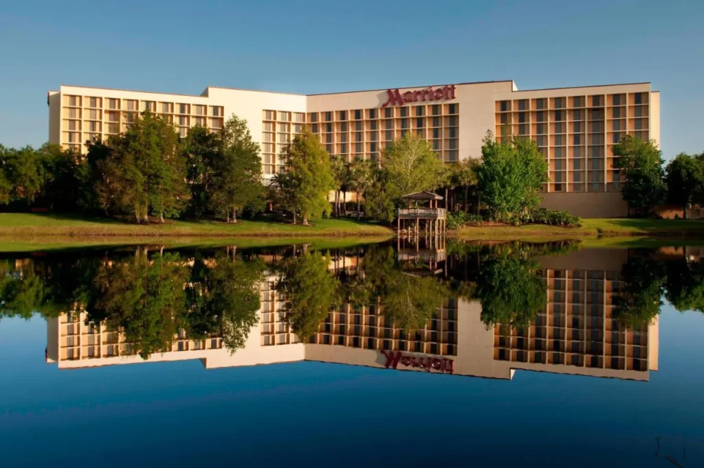 Marriott Orlando Airport Lakeside hotel reflected in the calm lake under a clear blue sky