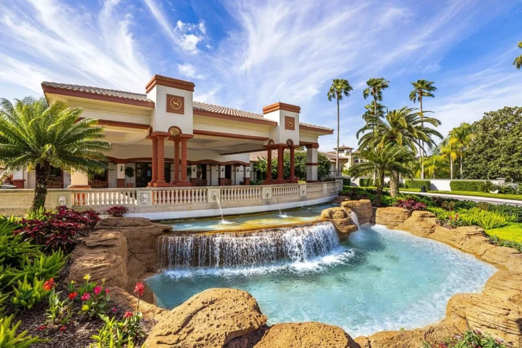 Pabell&oacute;n de llegada de estilo mediterr&aacute;neo con crestas Sheraton detr&aacute;s de una fuente de cascada de roca en Sheraton Vistana Villages