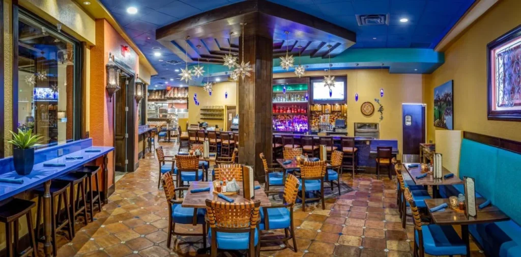 Comedor de estilo mexicano con sillas azules, linternas de estrellas y una barra trasera en Rosen Shingle Creek