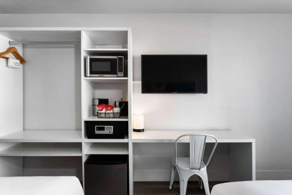 Microwave, mini-fridge, safe, TV and desk in a room at Baymont Orlando Lake Buena Vista South