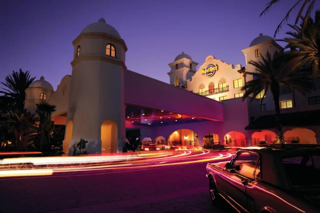 Mission-style entrance tower and porte-cochere lit up at dusk at Hard Rock Hotel Orlando