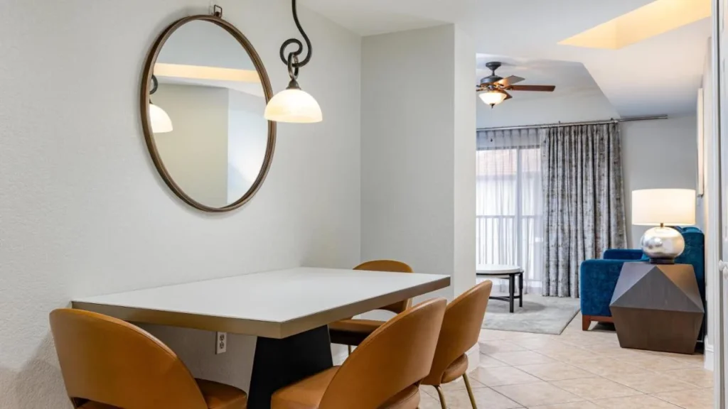 Modern dining table with leather chairs opening to a living room at Orange Lake Resort