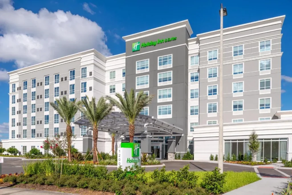 Modern exterior and palm-shaded entrance of Holiday Inn & Suites Orlando I-Drive - Theme Parks