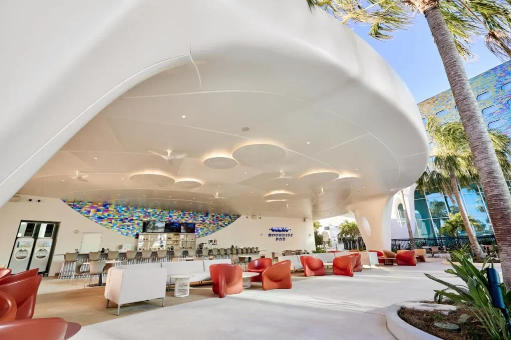 Sala de estar junto a la piscina cubierta Moonrise Bar con sillas de color naranja en Universal Terra Luna Resort