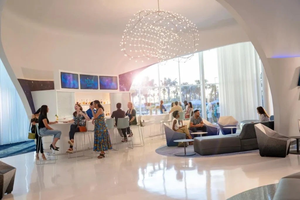 Nova Bar lobby lounge with a ring chandelier and tall windows at Universal Stella Nova Resort