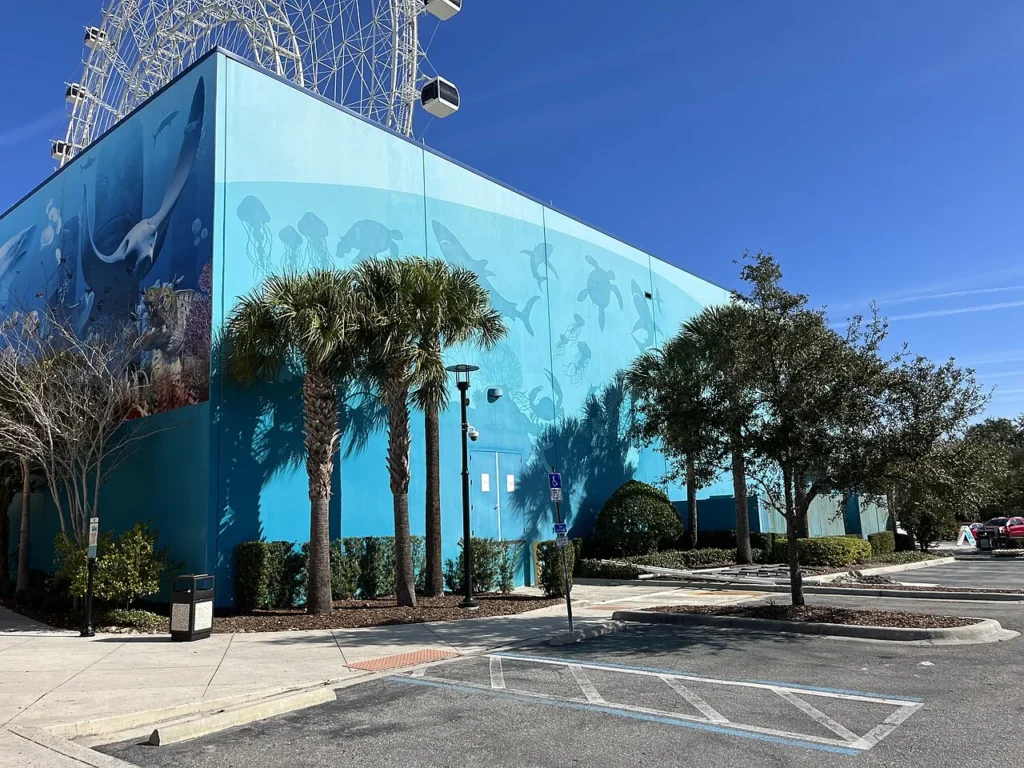 Ocean mural on the SEA LIFE Orlando Aquarium building with the ICON Park observation wheel above