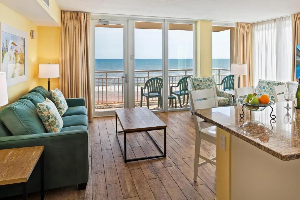 Sala de estar frente al mar con barra de desayuno de granito y balcón en Royal Floridian Resort Ormond Beach