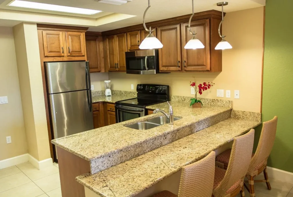 One-bedroom deluxe villa kitchen with full-size fridge, stove and breakfast bar at Westgate Lakes