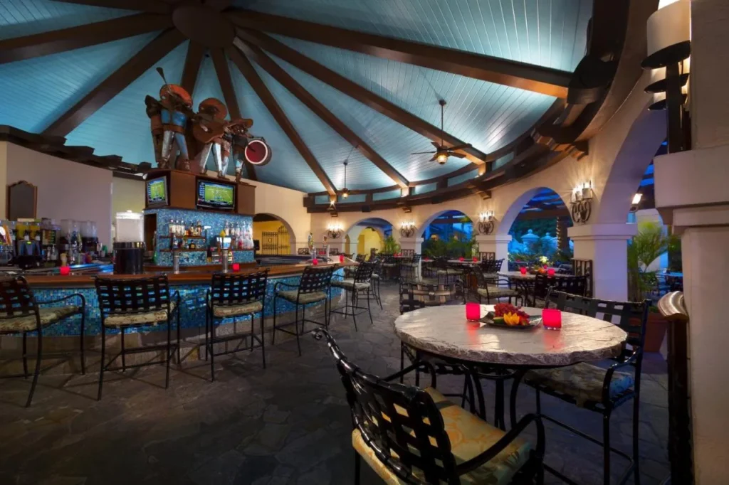Open-air bar with a blue tile counter, arches and wrought-iron seating at Hard Rock Hotel Orlando