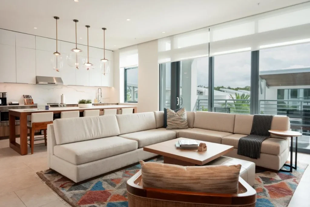 Open-plan living room with sectional sofa, kitchen island and balcony at Evermore Orlando Resort