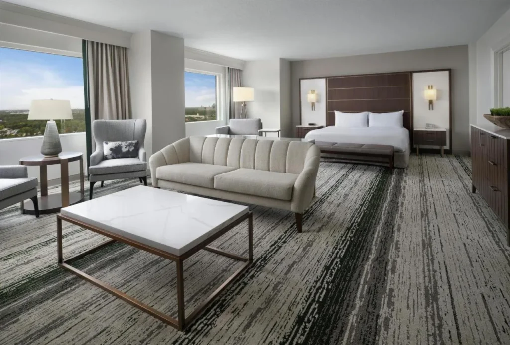 Suite de planta abierta con sofá, sillones y cama king en Signia by Hilton Orlando Bonnet Creek