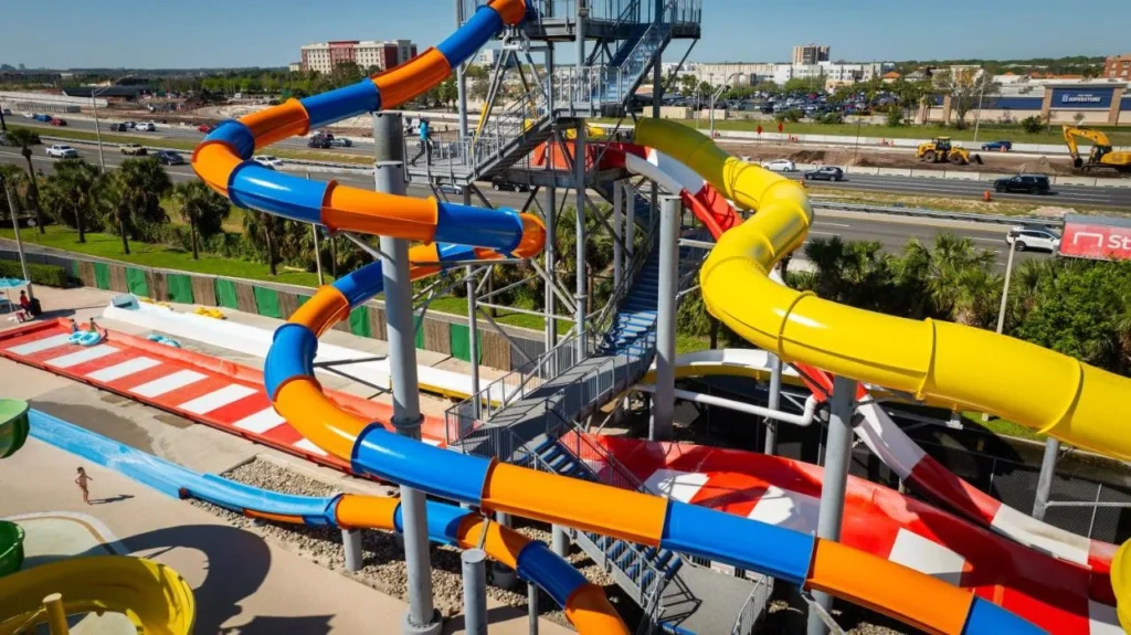 Toboganes de agua naranja, azul y amarillo girando alrededor de la torre deslizante en CoCo Key Water Resort