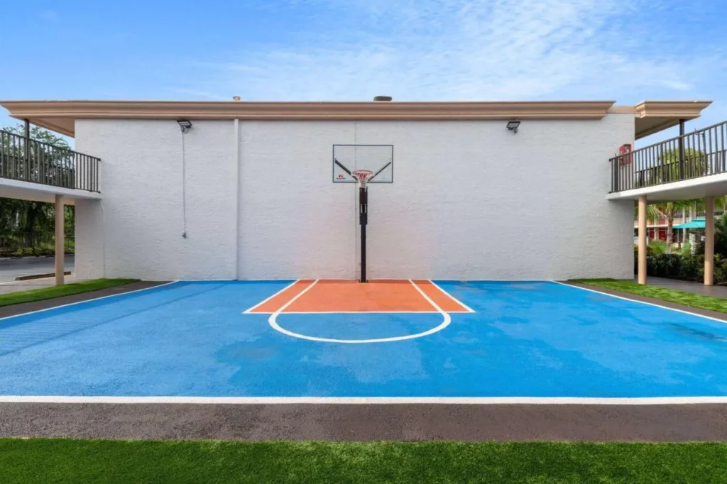 Media cancha de baloncesto al aire libre pintada de azul y naranja en Ramada by Wyndham Kissimmee Gateway