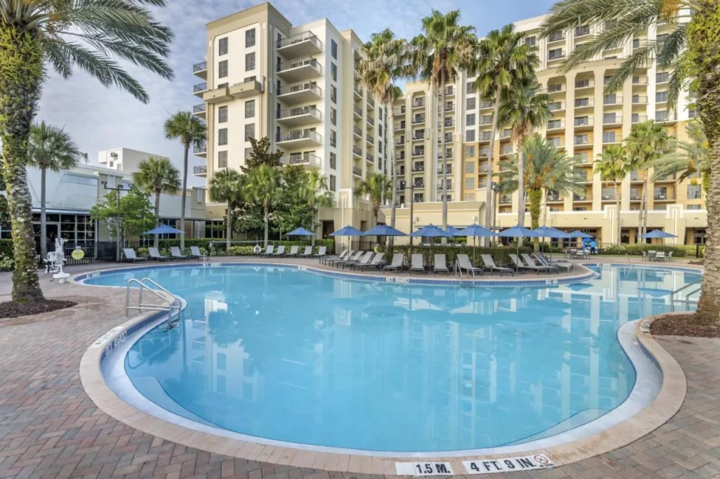 Piscina al aire libre y tumbonas debajo de las torres del hotel en Hilton Grand Vacations Club Las Palmeras