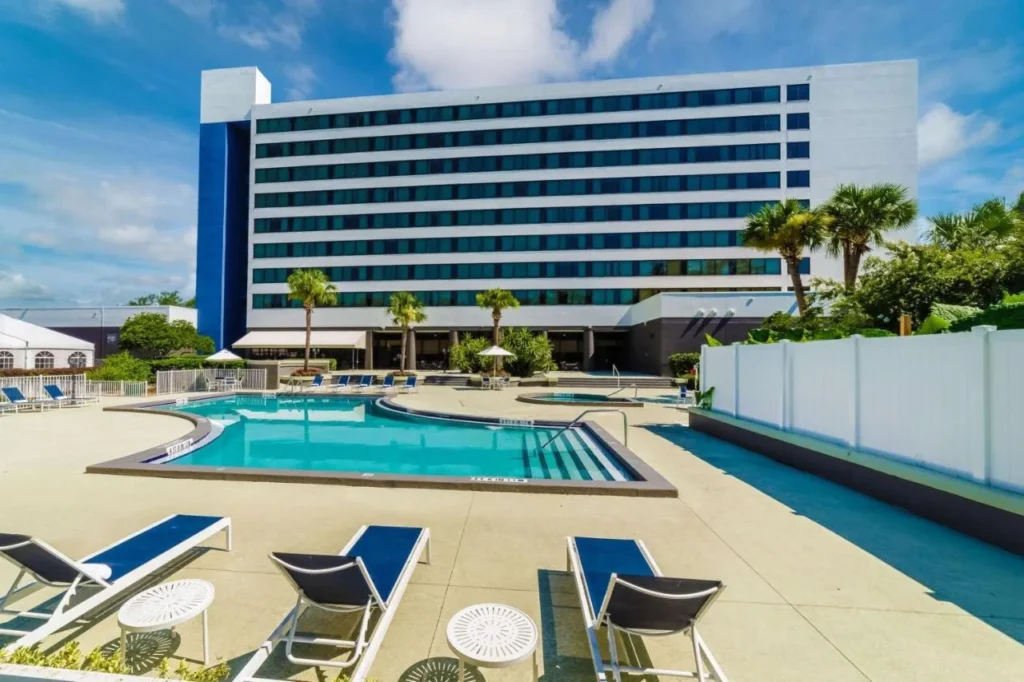 Piscina al aire libre y tumbonas frente a la torre del hotel Hilton Ocala