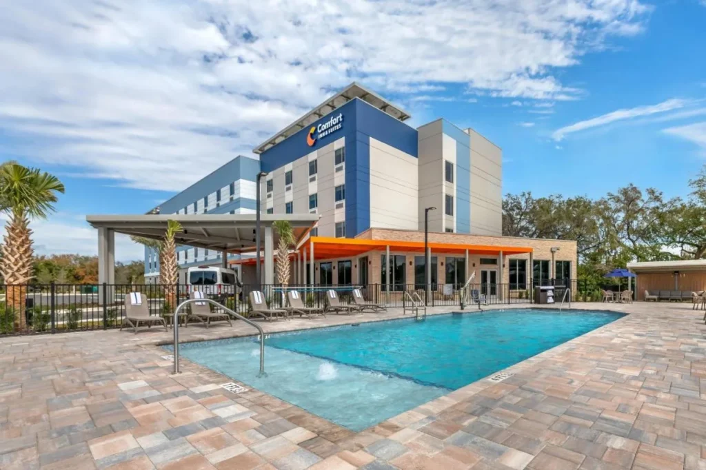 Outdoor pool and modern blue-and-white exterior of Comfort Inn & Suites Orlando Sanford Airport