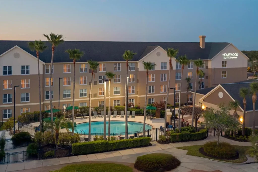 Piscina al aire libre y Courtyard con palmeras al atardecer en Homewood Suites by Hilton Orlando-UCF Área
