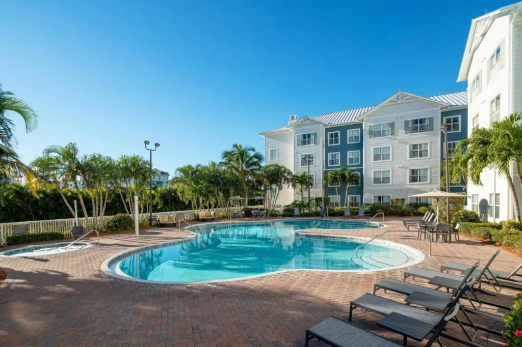 Outdoor pool and palm trees at Residence Inn by Marriott Cape Canaveral Cocoa Beach