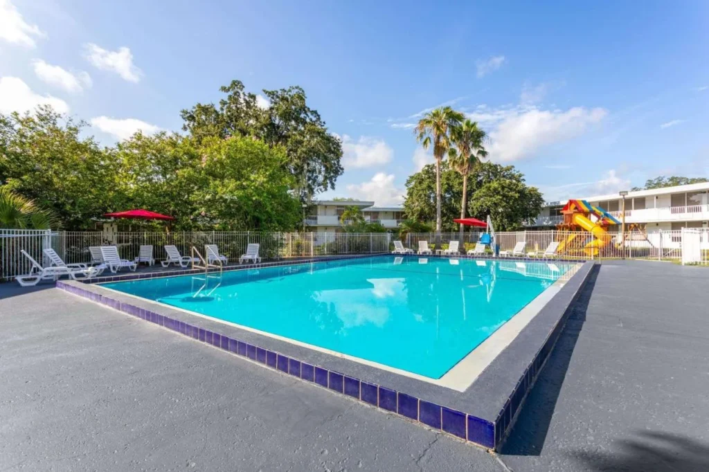Outdoor pool and playground slide at Baymont by Wyndham Orlando Lake Buena Vista South