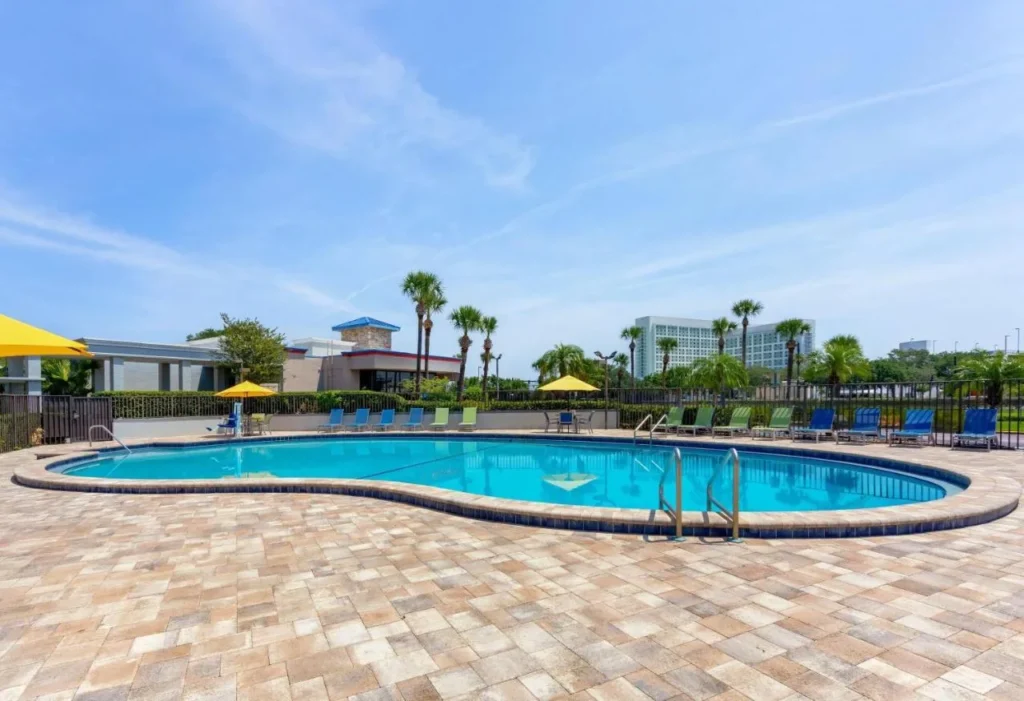 Piscina al aire libre y tumbonas en Days Inn by Wyndham Orlando Convention Center/International Drive