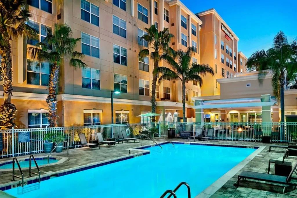 Piscina al aire libre y bañera de hidromasaje iluminada al atardecer debajo del edificio Residence Inn Orlando Lake Mary