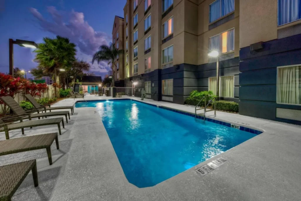 Outdoor pool beside the guest wing at dusk at Fairfield Inn & Suites Orlando Near Universal