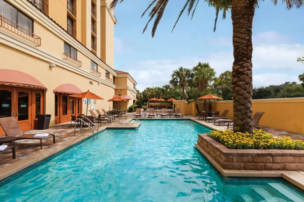 Outdoor pool beside the yellow hotel wing at Embassy Suites Orlando International Drive Convention Center