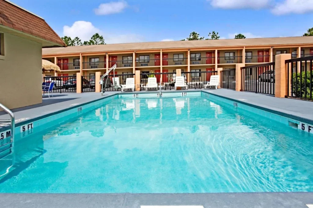 Piscina al aire libre frente al ala de la habitaci&oacute;n de dos pisos en Super 8 by Wyndham Kissimmee Maingate