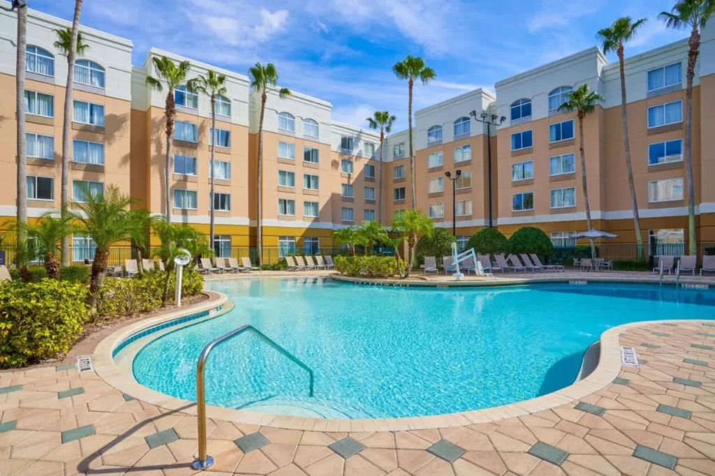 Outdoor pool surrounded by palms and guest wings at SpringHill Suites in the Marriott Village