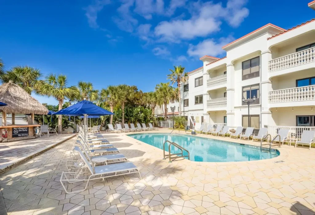 Outdoor pool, tiki hut and white hotel building at Hampton Inn & Suites St. Augustine-Vilano Beach
