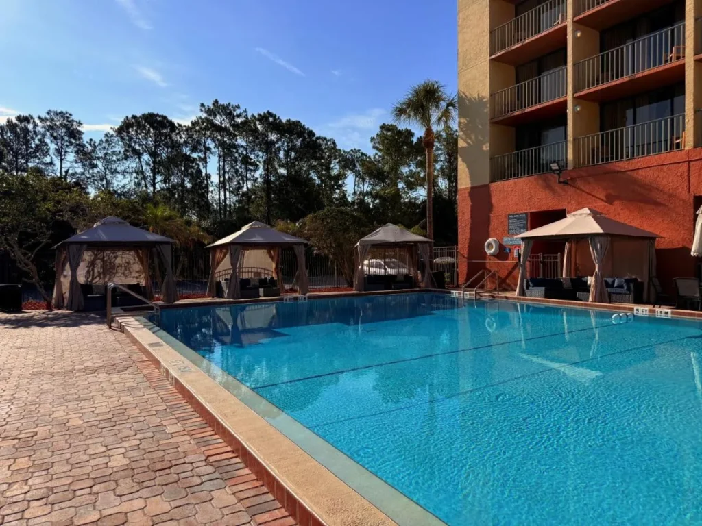 Outdoor pool with curtained cabanas beside the tower at Holiday Inn & Suites Orlando SW