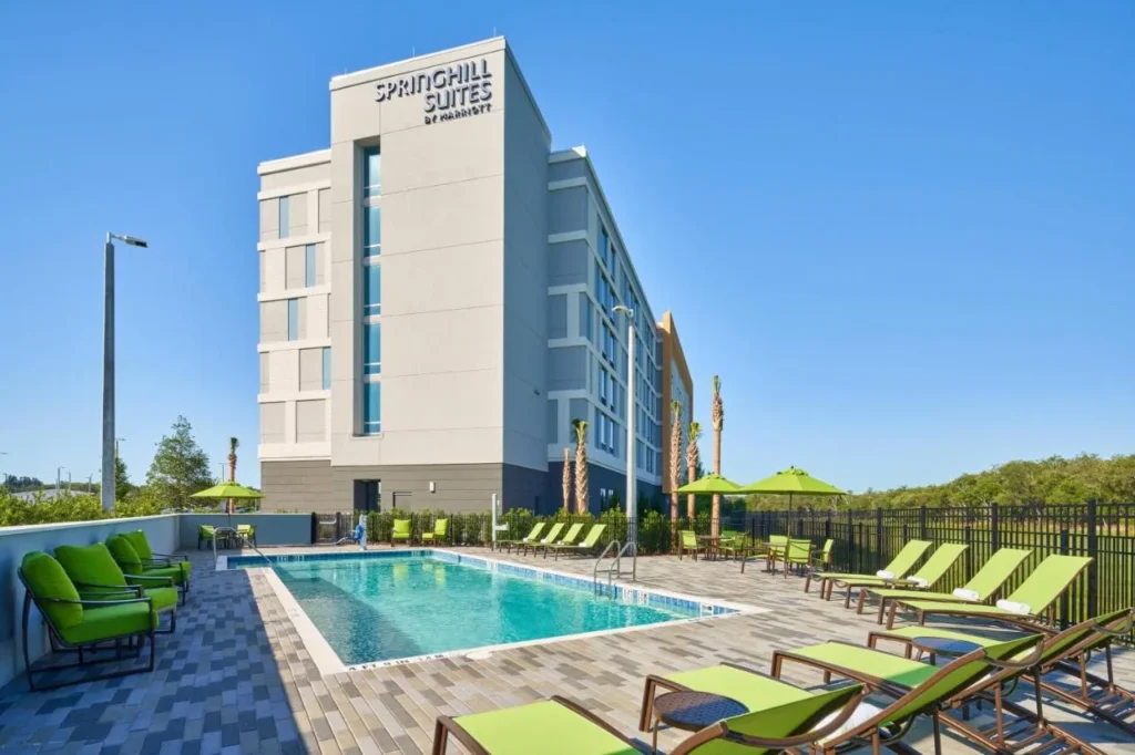 Piscina al aire libre con tumbonas verdes junto a SpringHill Suites by Marriott Orlando Lake Nona