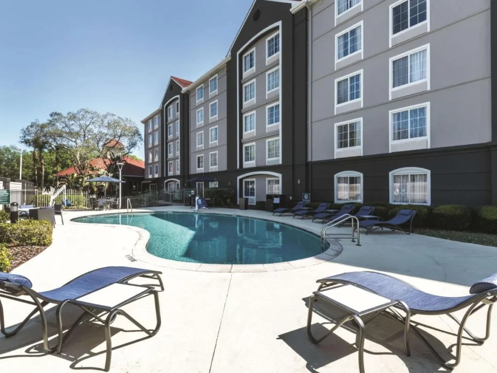 Piscina al aire libre con tumbonas junto al edificio La Quinta by Wyndham Orlando Lake Mary