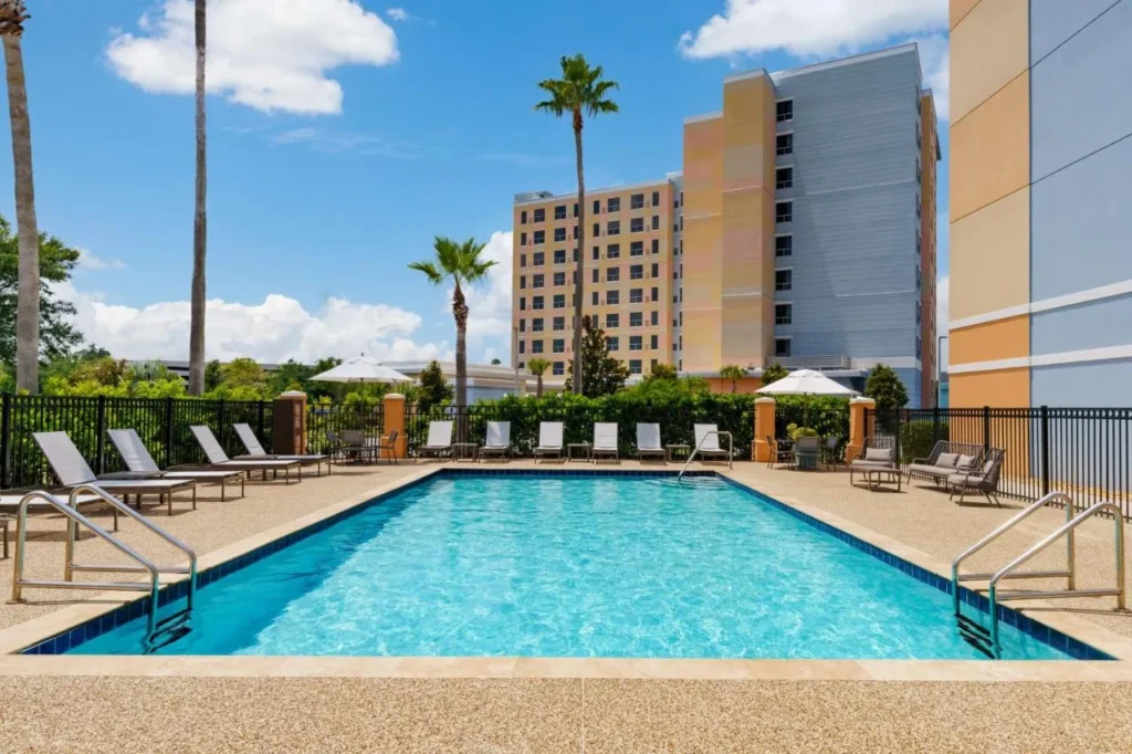 Outdoor pool with loungers beside the hotel tower at Hyatt Place across from Universal Orlando