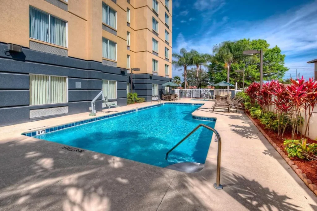 Piscina al aire libre con palmeras junto al ala de invitados en Fairfield Inn & Suites Near Universal