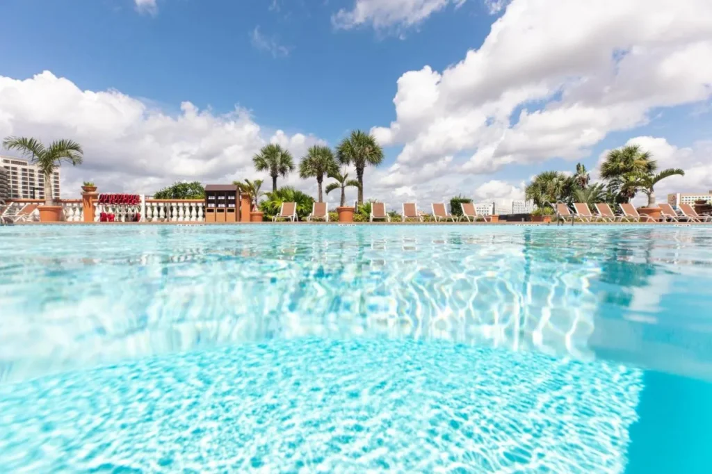 Outdoor pool with palm trees, lounge chairs and a white balustrade at Westgate Palace near Universal