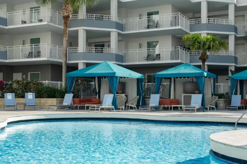 Outdoor pool with teal cabanas below balconies at Embassy Suites Lake Buena Vista Resort