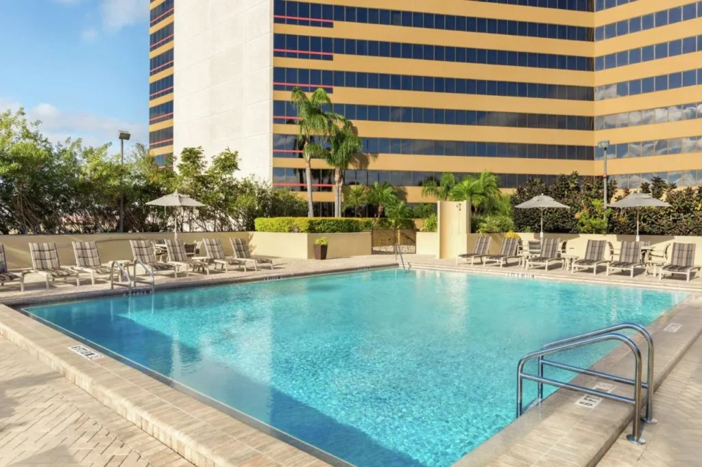 Outdoor sky-deck pool and loungers below the DoubleTree by Hilton Orlando Downtown tower