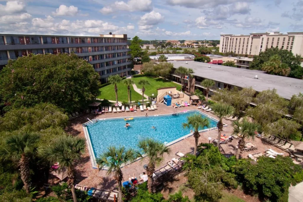 Overhead view of a pool, palm trees and guest wings at Rosen Inn International