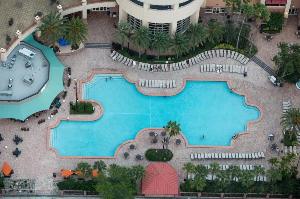 Overhead view of the large curved outdoor pool, loungers and pool deck at Rosen Centre Hotel